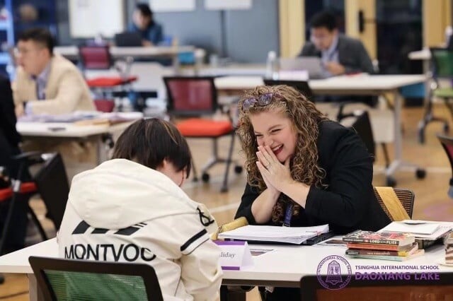 Teacher smiling with a student in class